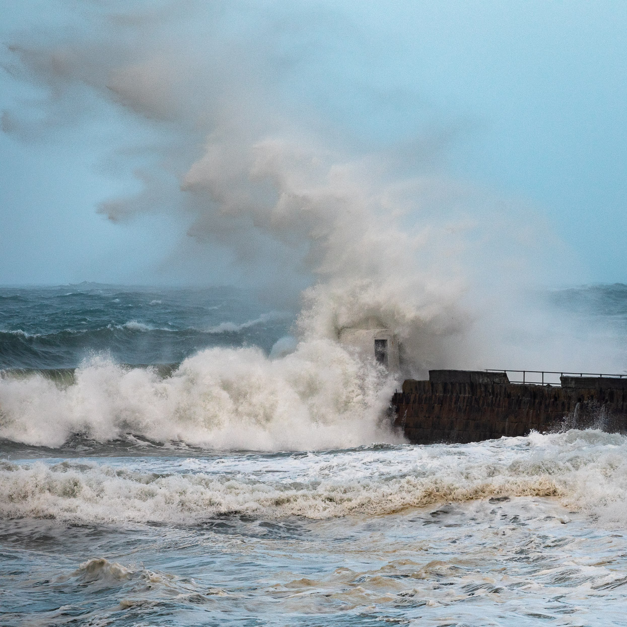 A giant wave towers above the breakwater at Portreath, Cornwall during storm Ciara - David Gibbeson